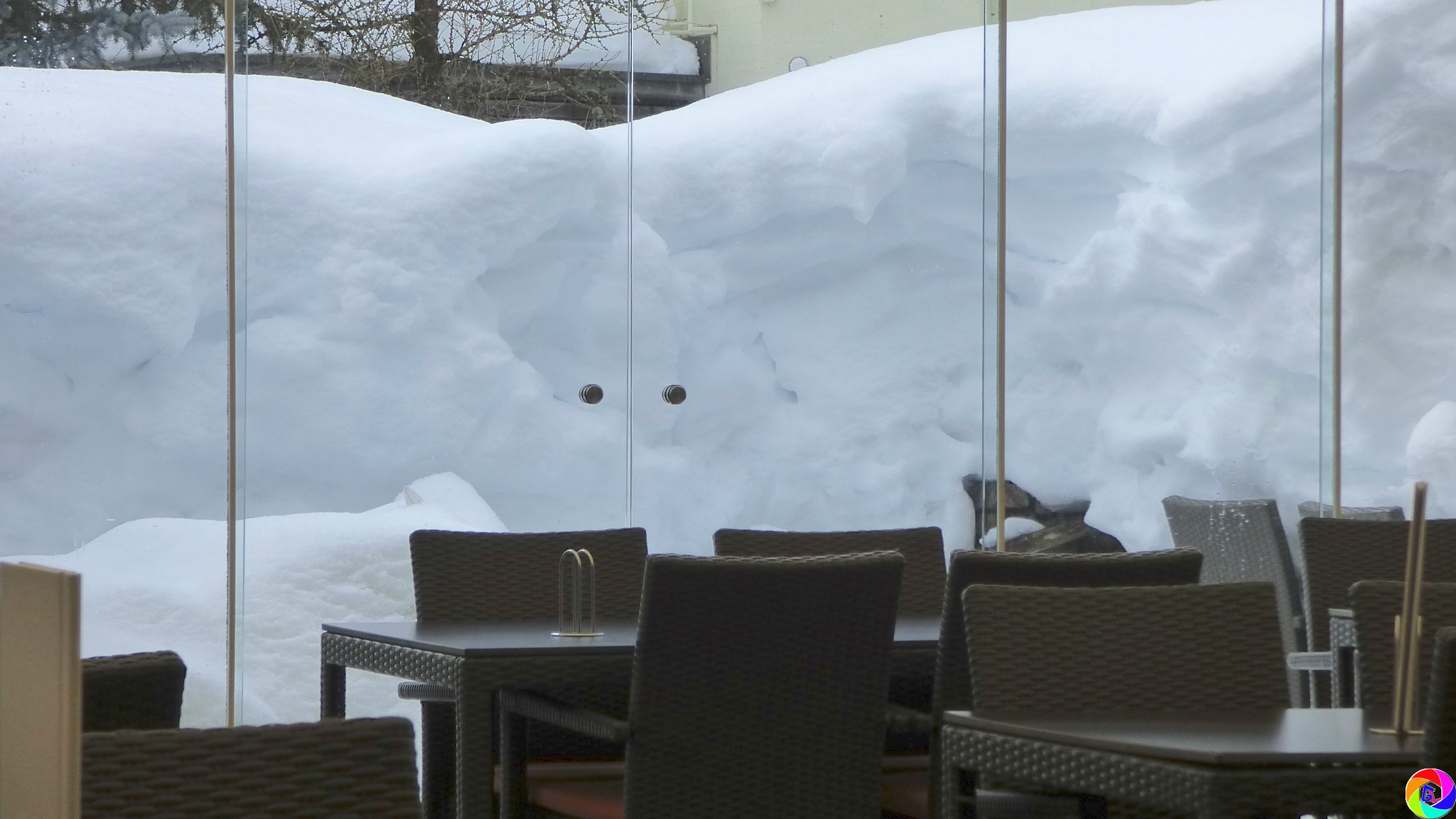 Snow fallen thick on outdoor cafe tables